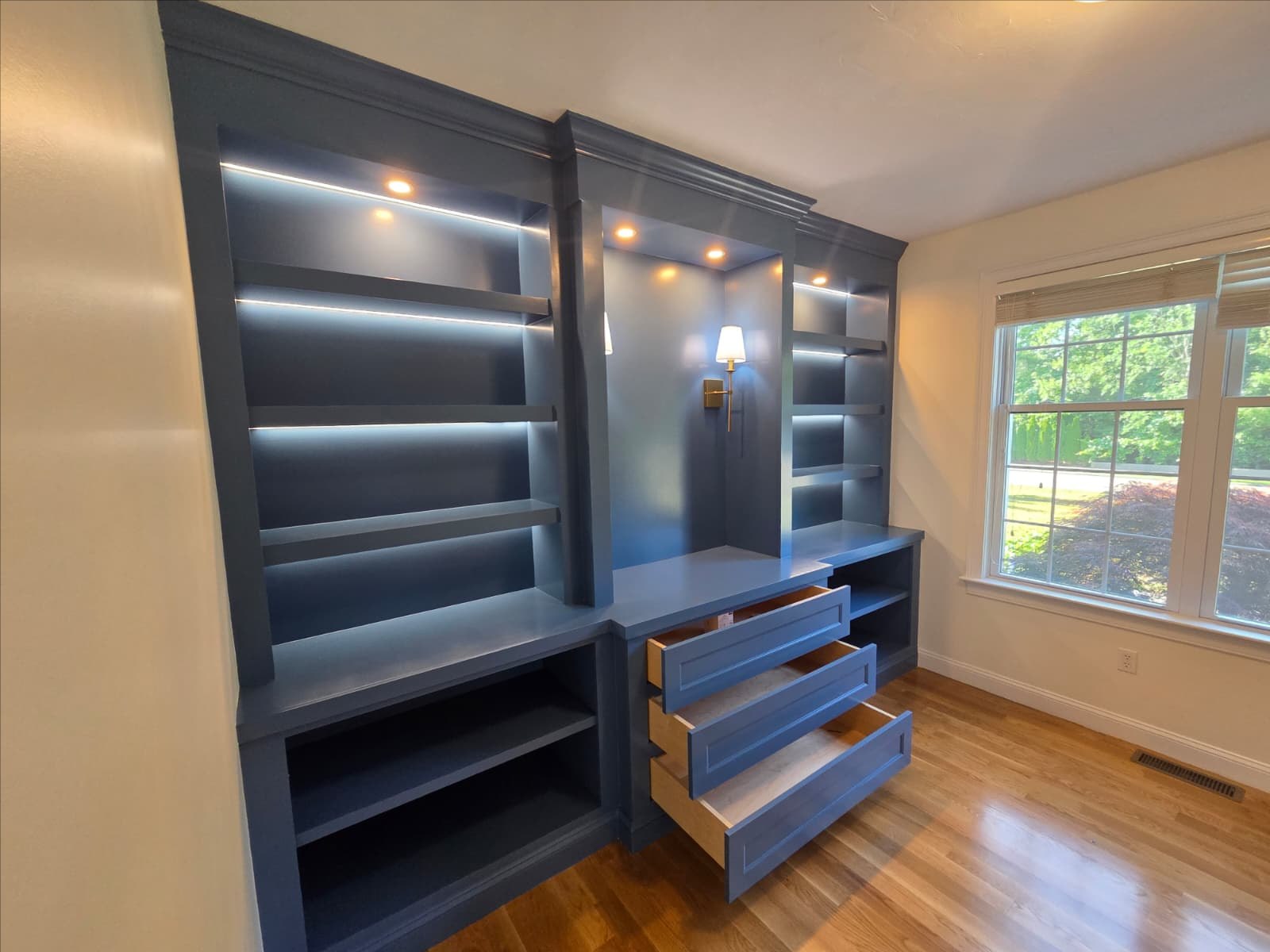 Custom blue built-in cabinetry with integrated lighting during installation by Marco Solution & Services